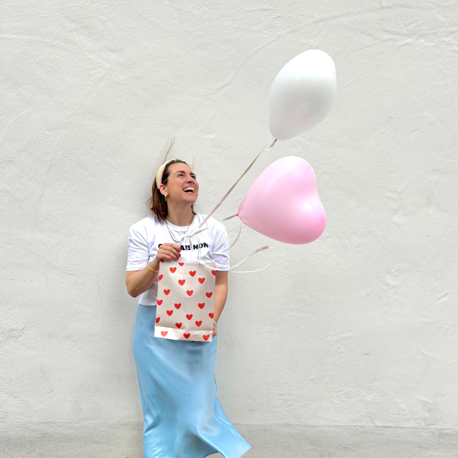 Geschäftsinhaberin mit Goodie Bag und Luftballons